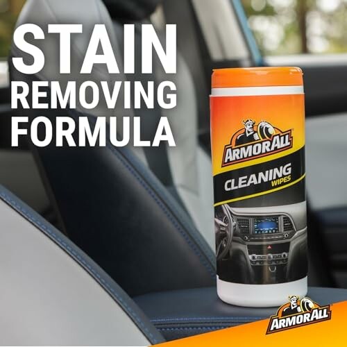 Armor All cleaning wipes container on car seat with stain removing formula text.