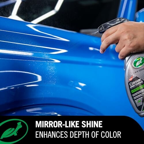 Applying ceramic spray coating on blue car for mirror-like shine.